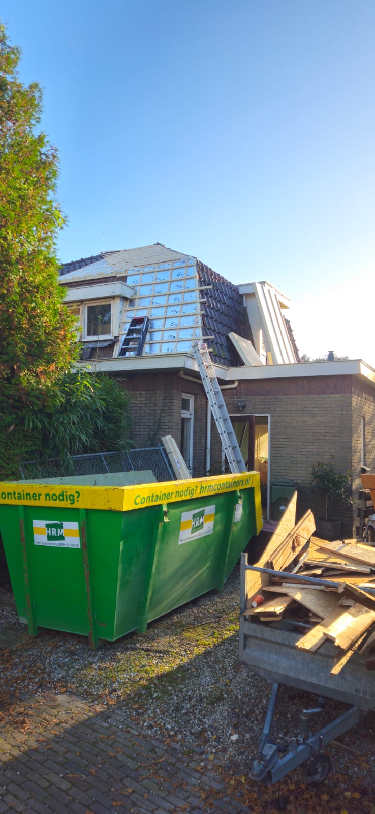 Dakdekker op dak bezig met noodreparatie
